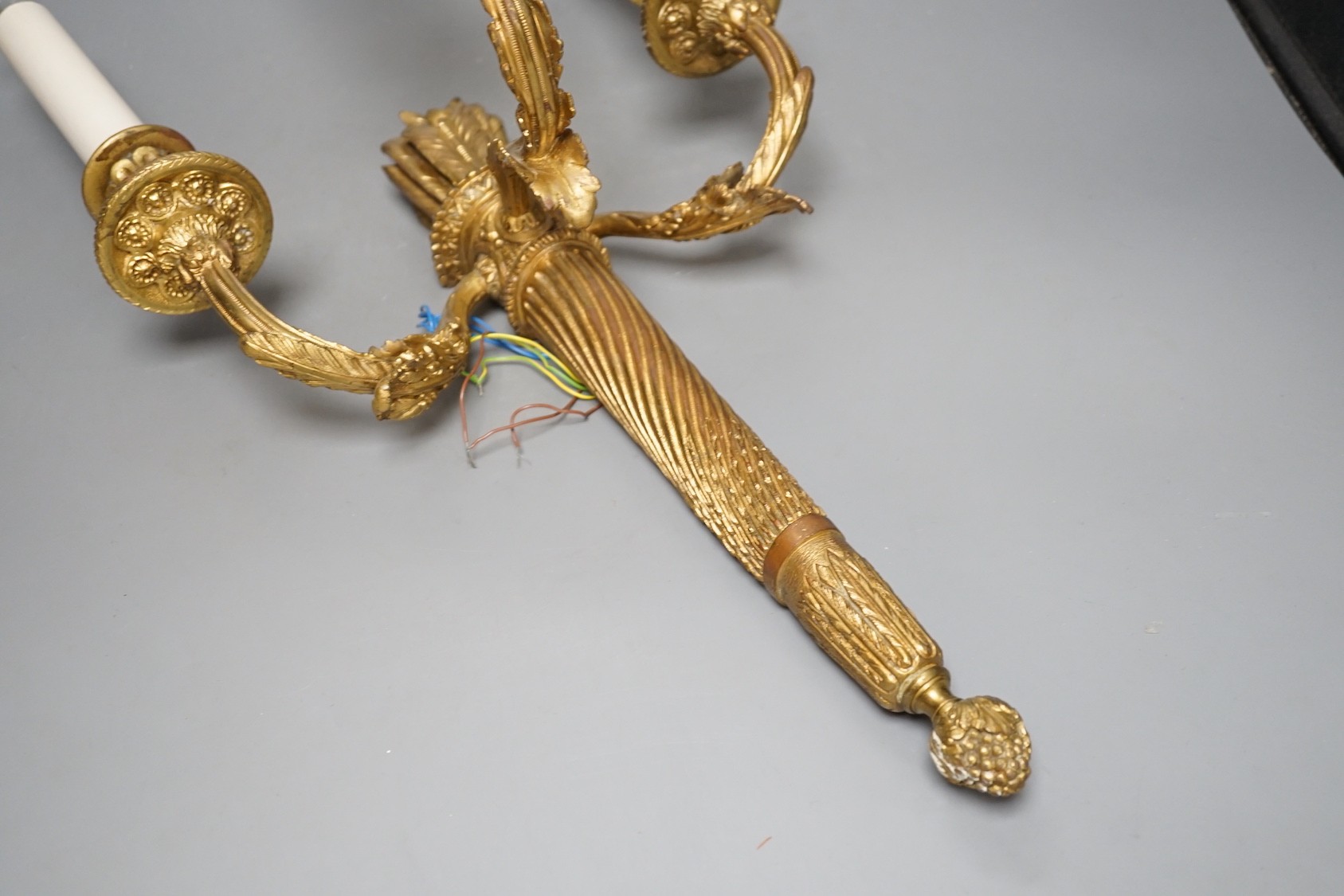 A Louis XVI style gilt bronze ‘bow and quiver’ three branch wall sconce - 59cm tall